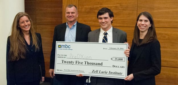 Michigan Business Challenge winners, holding their investment check